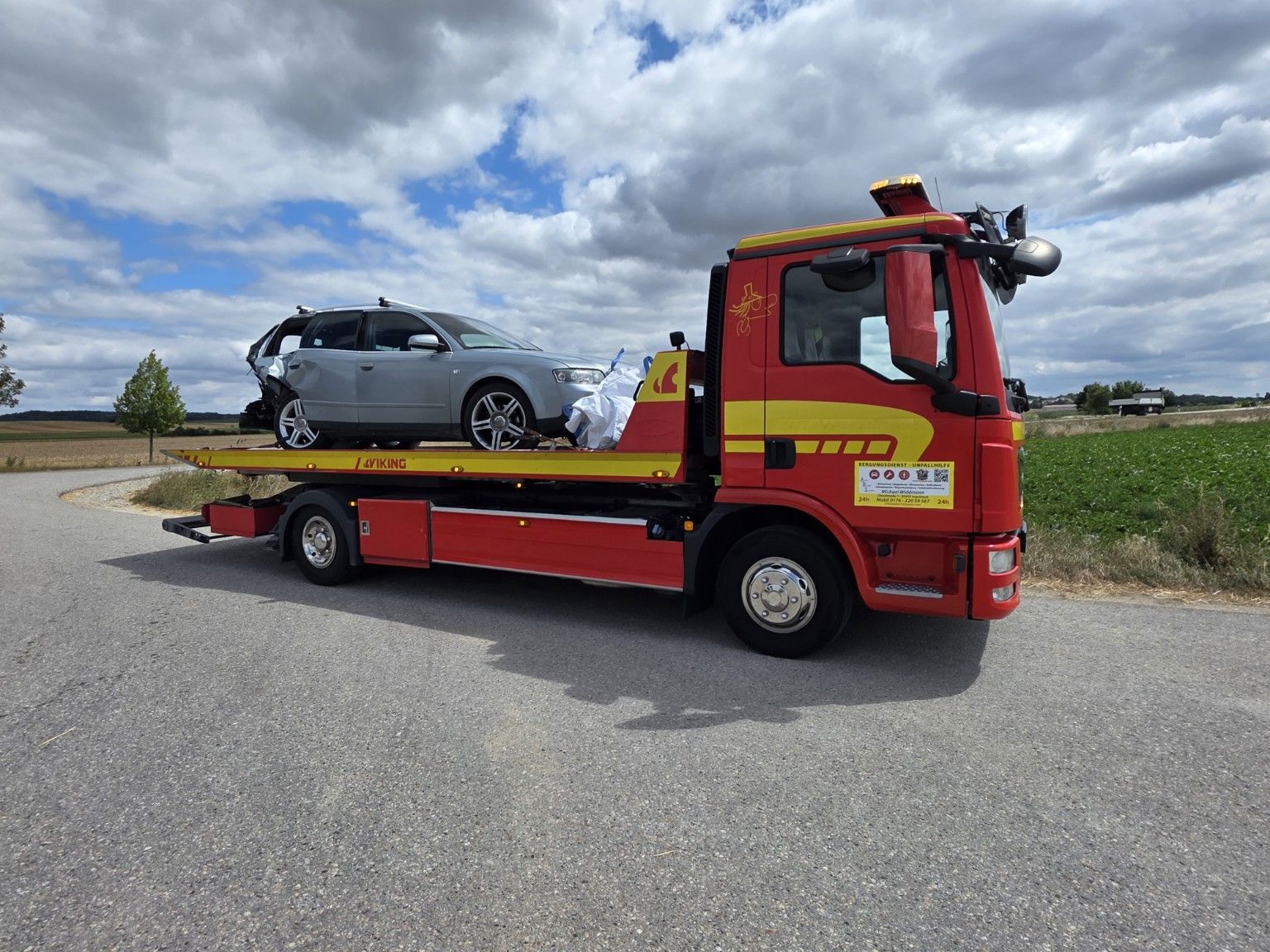 Rotes ABS Bergungsfahrzeug mit Drehplateau und verladenem Unfallfahrzeug